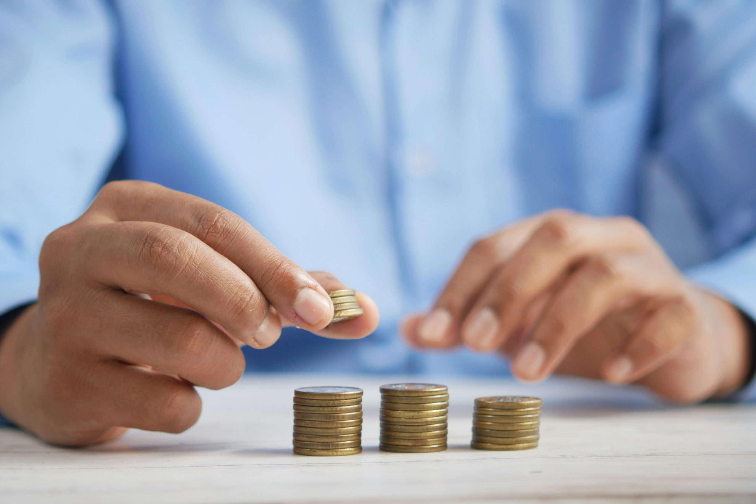 Person stacking coins to calculate whether they meet the income threshold to file taxes in 2025