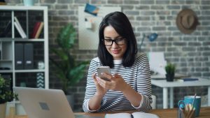 A small business owner reviewing tax extension options on her phone at her home office desk