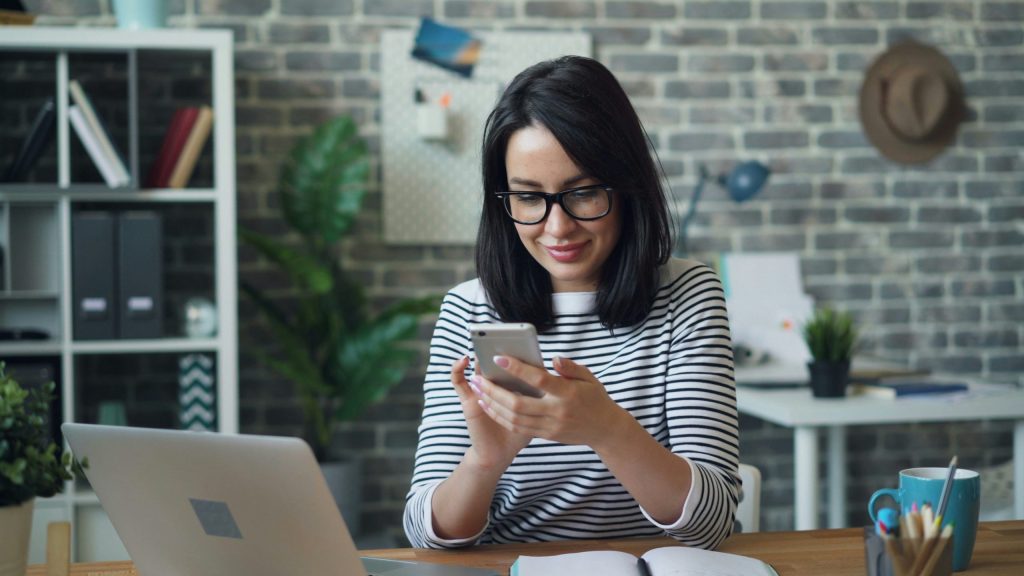 A small business owner reviewing tax extension options on her phone at her home office desk