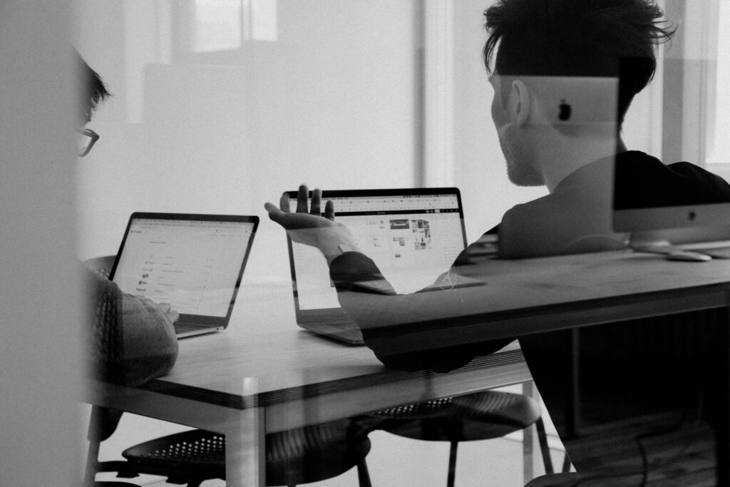 Person reviewing an IRS tax transcript document at a desk with paperwork and a laptop